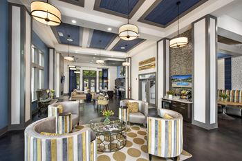 A modern living room with a striped sofa and a glass coffee table.